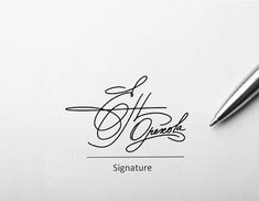 signature written in cursive writing on white paper with fountain pen next to it