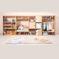 a child's closet with clothes and toys on the floor in front of it