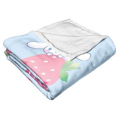 a blue and pink blanket sitting on top of a white bedding set with polka dots