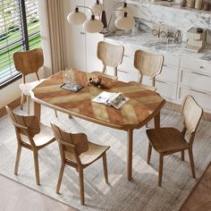 a dining room table with four chairs and a rug on the floor in front of it