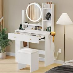 a white vanity table with a mirror and stool in a living room next to a lamp