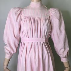 "This is a antique wrapper from the late 1800's (1870s-1890s). It is pink and white plaid cotton. Pink is pretty unusual as most of these are usually indigo or brown. I love the tent like style of this dress and how wearable it is without looking like you are wearing a costume. Often period dresses look period, the color, fabric and cut of this dress are very much now. It looks like the fabric could be homespun. The dress has mandarin style stand collar with an asymmetrical button neck opening. Victorian Cotton Prairie Dress For Daywear, Victorian Cotton Prairie Dress For Spring, Vintage Pink Prairie Dress For Daywear, Pink Vintage Prairie Dress For Daywear, Cottagecore Victorian Dress For Daywear, Cotton Victorian Cottagecore Dress For Daywear, Cottagecore Victorian Cotton Dress For Daywear, Spring Cotton Regency Prairie Dress, Spring Regency Style Cotton Prairie Dress