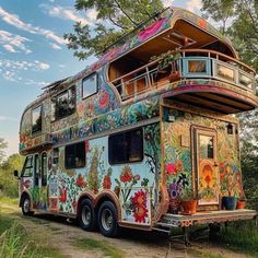 a multicolored bus is parked on the side of the road in front of some trees