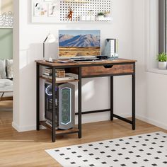 a desk with a computer sitting on top of it next to a window in a living room