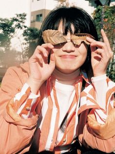 a woman with glasses holding up a leaf