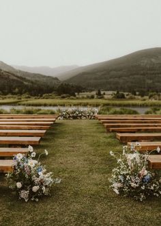 rows of wooden benches sitting on top of a lush green field