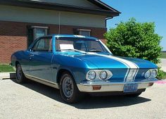 a blue and white car parked in front of a building