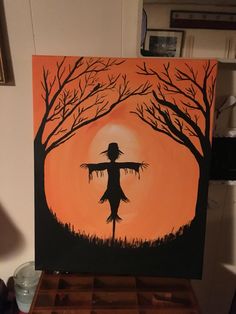 an acrylic painting of a scarecrow in front of a sunset