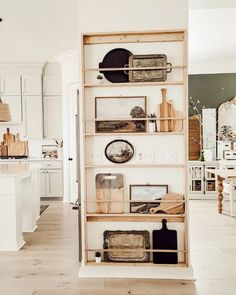 an open book shelf in the middle of a kitchen