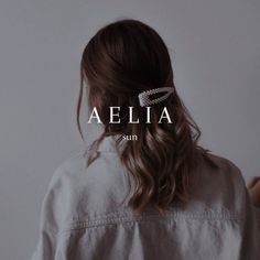 a woman wearing a white shirt with the word aelia written across her left shoulder