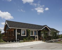 a small house with a black roof and white trim