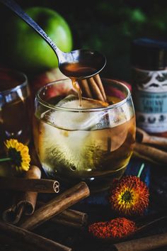 an apple cider with cinnamon sticks and apples in the background