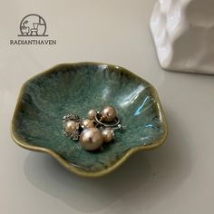 two pearls are sitting in a green bowl