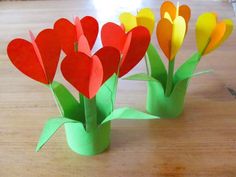 several paper flowers sitting on top of a wooden table