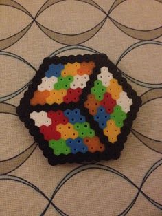 a colorful brooch sitting on top of a table next to a black and white wall