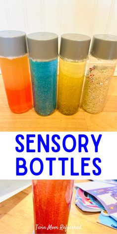 four bottles filled with different colored liquid sitting on top of a wooden table next to each other