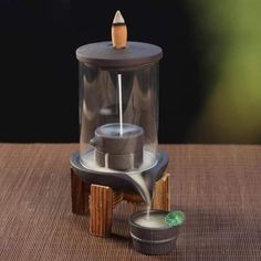 a miniature model of a teapot on a table with a small pot in front of it