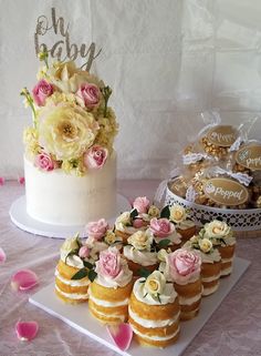 a table topped with cakes and cupcakes next to a cake covered in frosting