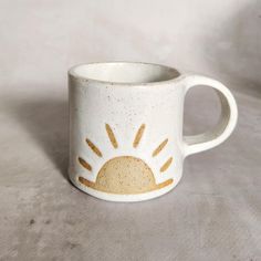 a coffee mug with the sun painted on it