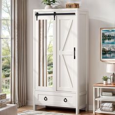 a white armoire in a living room next to a window with curtains on it