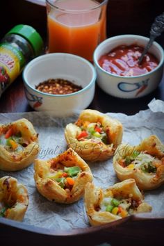 small appetizers are sitting on a tray with drinks and condiments around them