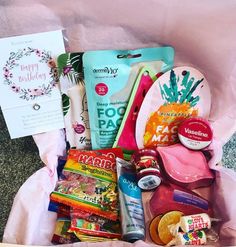 an open gift box filled with lots of goodies and snacks on top of a table