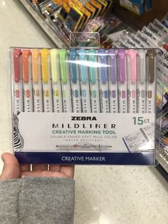 a hand holding a box of zebra mildliner markers in it's display case