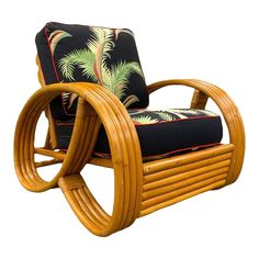 a chair made out of bamboo with a black cushion and palm leaves on the back