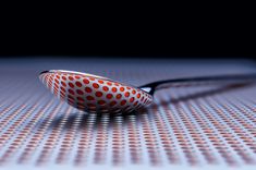 a polka dot bowl sitting on top of a table next to a pair of scissors