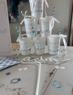 there are many cups on the table with blue and white straws