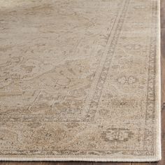 a beige rug with an intricate design on the top and bottom, sitting on a wooden floor