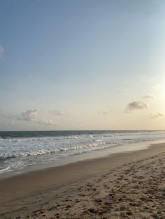 an empty beach with waves coming in to shore