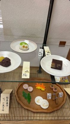 an assortment of desserts on display in a glass case