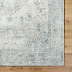 an area rug on a wooden floor with a blue and white color scheme in the middle