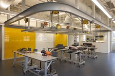 an office building with tables and chairs in the center, yellow partitions on the walls