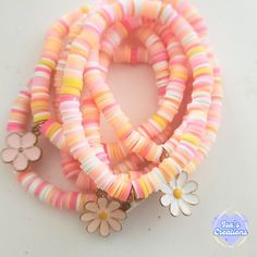 multicolored bracelets with flowers and charms on them sitting on a white surface