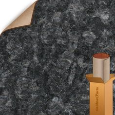 a black granite counter top with gold trimmings and an orange box on it