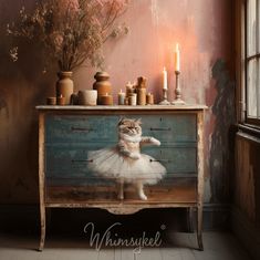 a cat sitting on top of a dresser next to a vase with flowers and candles