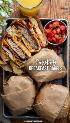 the cowboy breakfast bagels are ready to be eaten with orange juice and strawberries