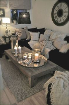 a living room filled with lots of furniture and candles on top of a coffee table