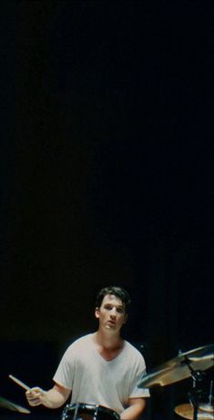 a man sitting in front of a drum set