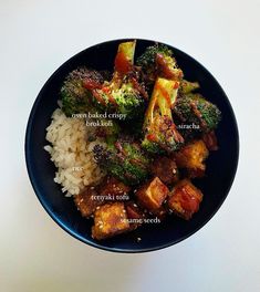 a bowl filled with rice, broccoli and tofu on top of it