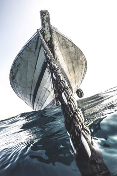 an old boat in the water with rope on it's front end and back end