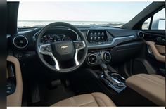 the interior of a car with dashboard, steering wheel and center console in front of an ocean view