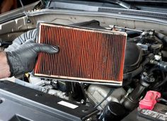 a man is working on an engine in the garage with his gloved hand over the radiator