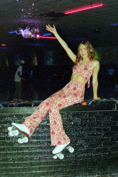 a woman riding a skateboard on top of a wall