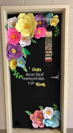 a door decorated with paper flowers and a quote