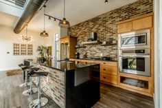 a kitchen with an island and two stools in front of the stove top oven