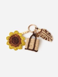 two crocheted keychains one with a flower and the other has a feather