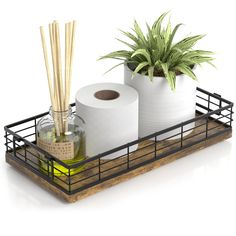 two rolls of toilet paper are sitting in a metal holder with bamboo sticks and a bottle